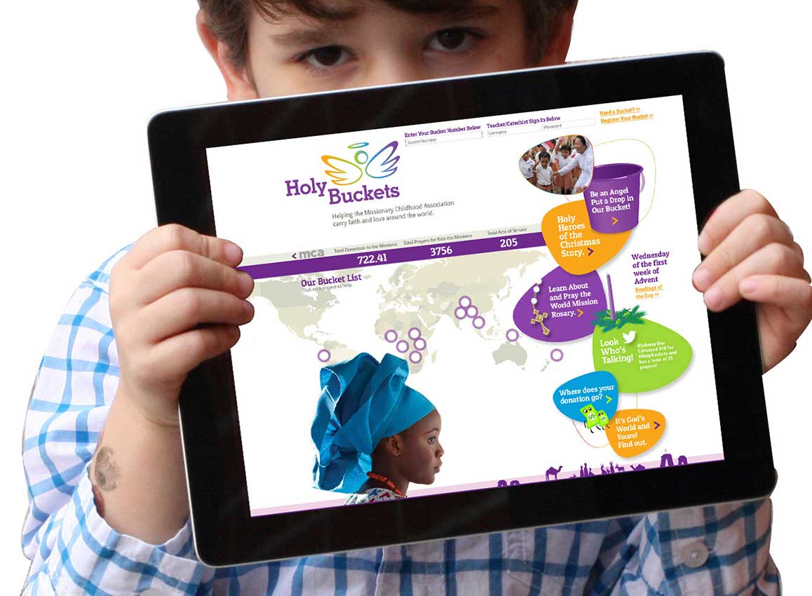 Young boy holding an iPad showing the website design for Holy Buckets, an awareness and fundraising program, created for the nonprofit organization Missionary Childhood Association.